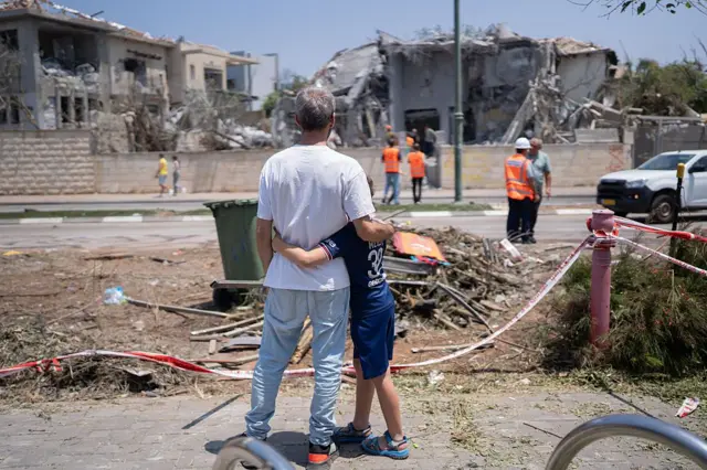 A father and his son in front of his house destroyed.