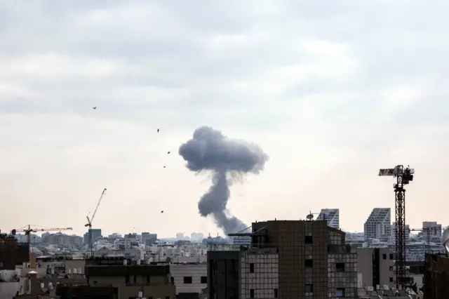 Smoke in the background and urban profile of Tel Aviv buildings